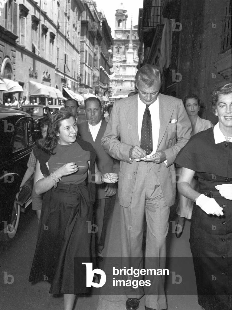Gary Cooper signing an autograph to a girl, Rome, Italy, 1957 (b/w photo)