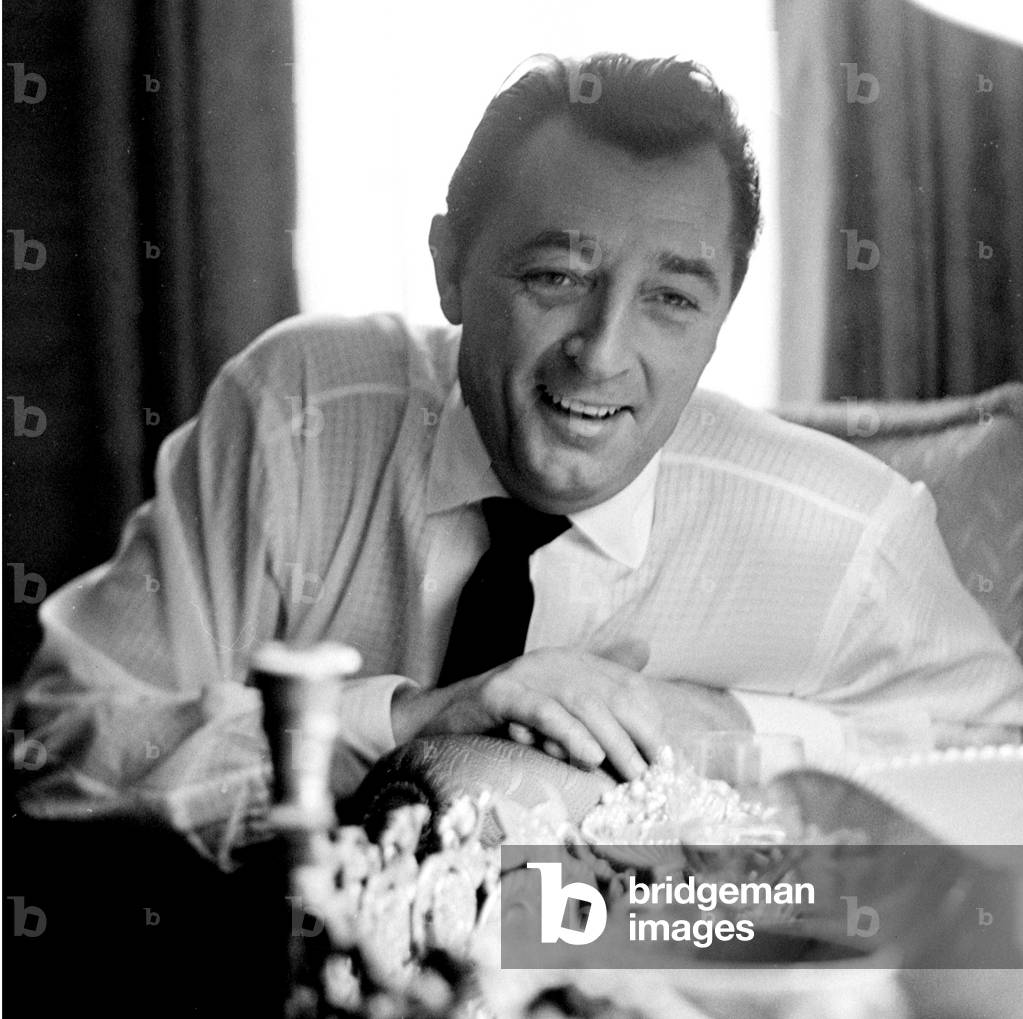Robert Mitchum telling a joke, London, UK, 1960 (b/w photo)