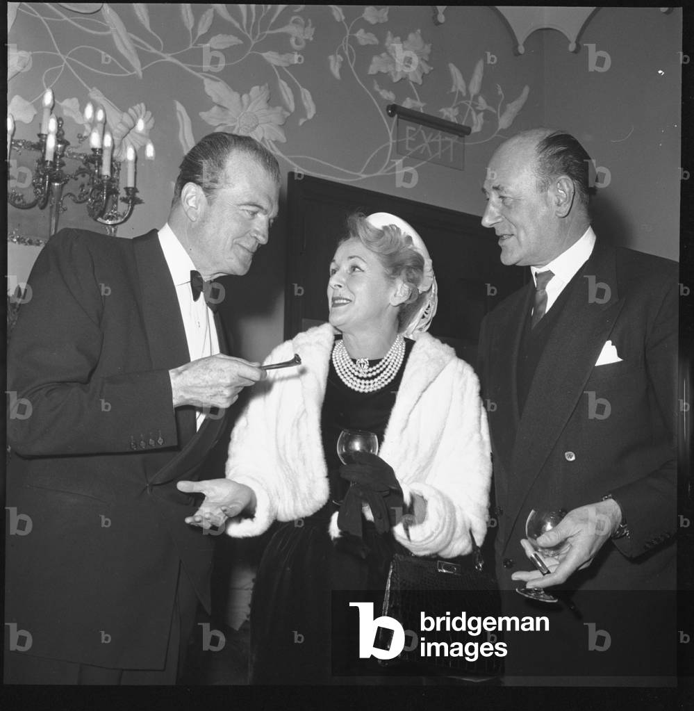 George Sanders with wife Benita Hume and friend, Quaglino's, London, UK, 1959