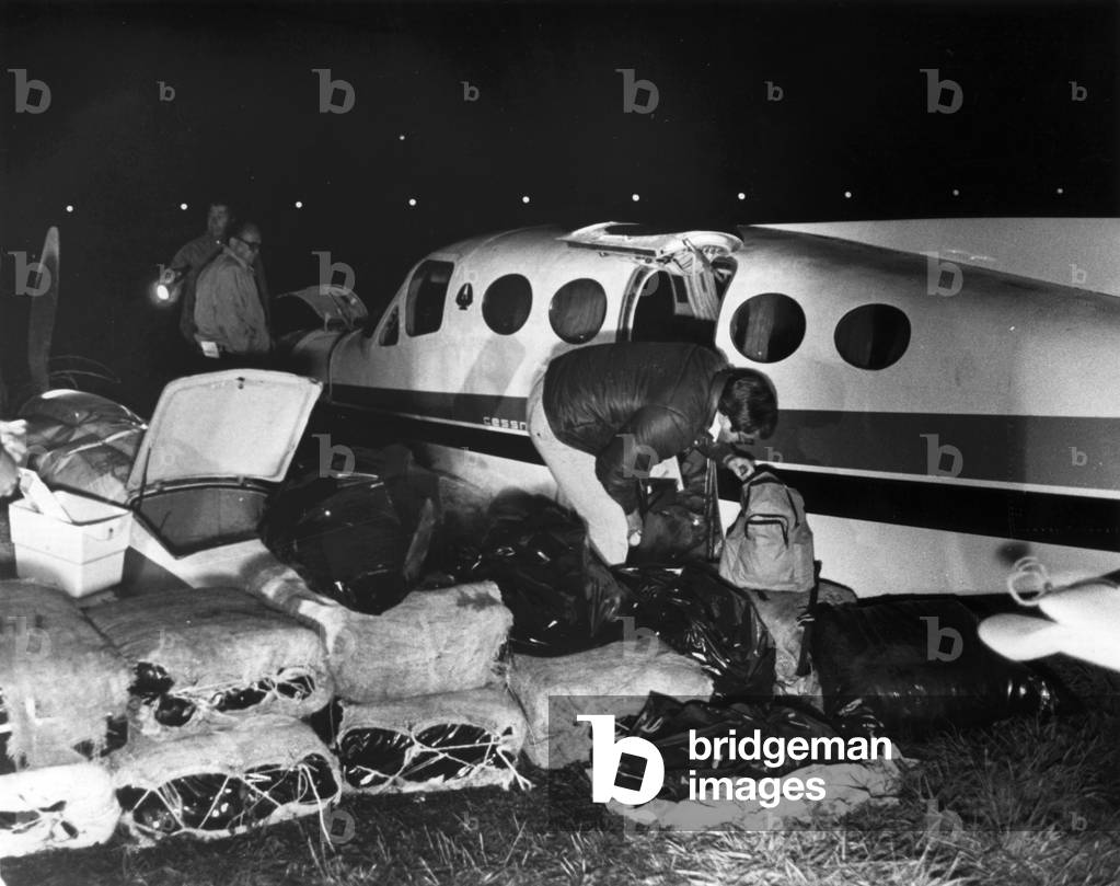 Bales of marijuana spill out from a crashed Cessna plane, 1978 (b/w photo)