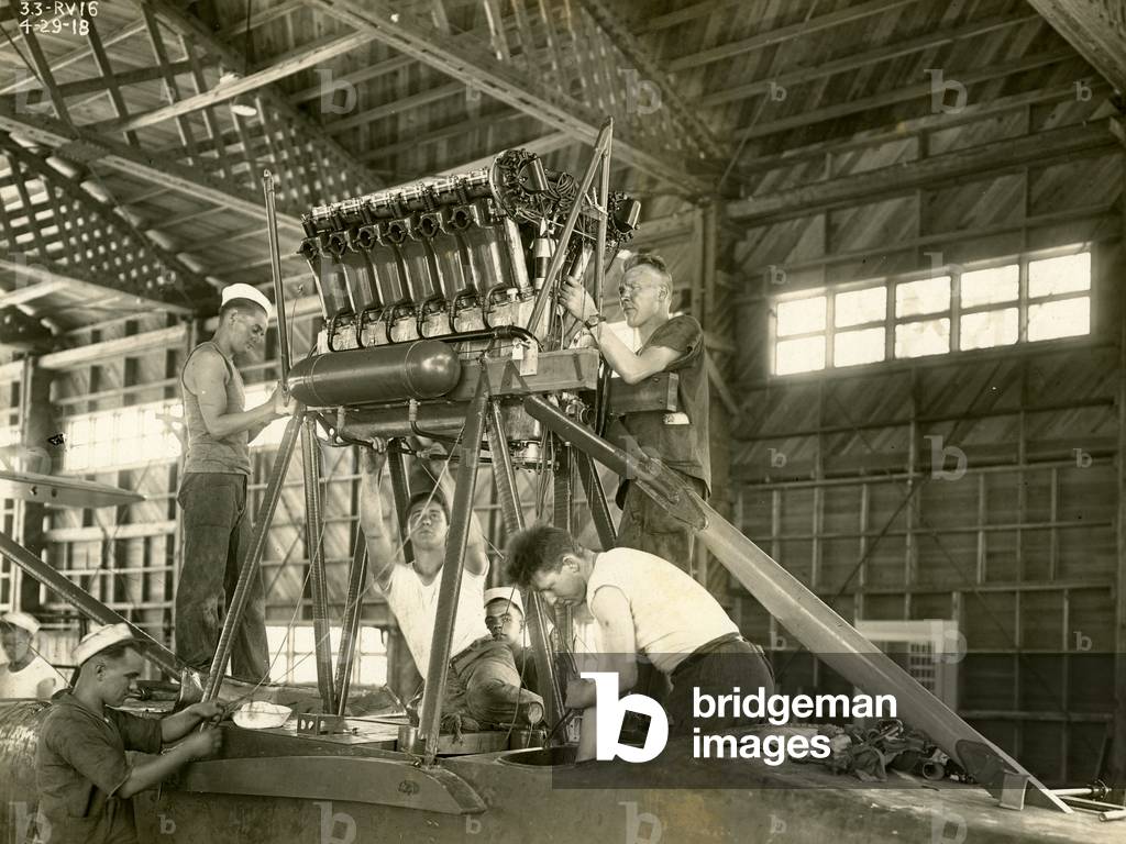 Naval mechanics working on an airplane in a hangar at the U. S. Naval Air Station at Dinner Key, 1918 (b/w photo)