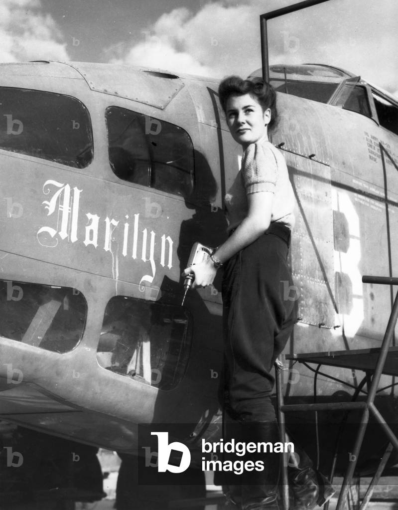 'Rosie the Riveter' repairs an airplane at the Miami Air Depot, November 11, 1943 (b/w photo)