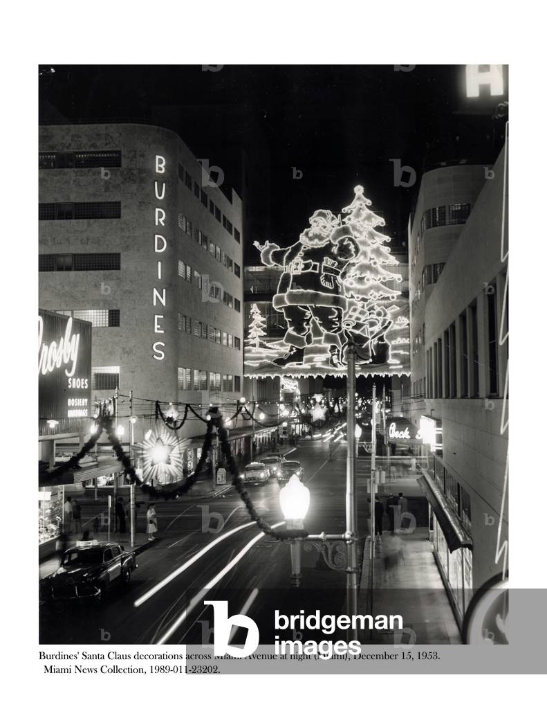 Burdines' Santa Claus decorations across Miami Avenue at night, 15 December 1953 (photo)