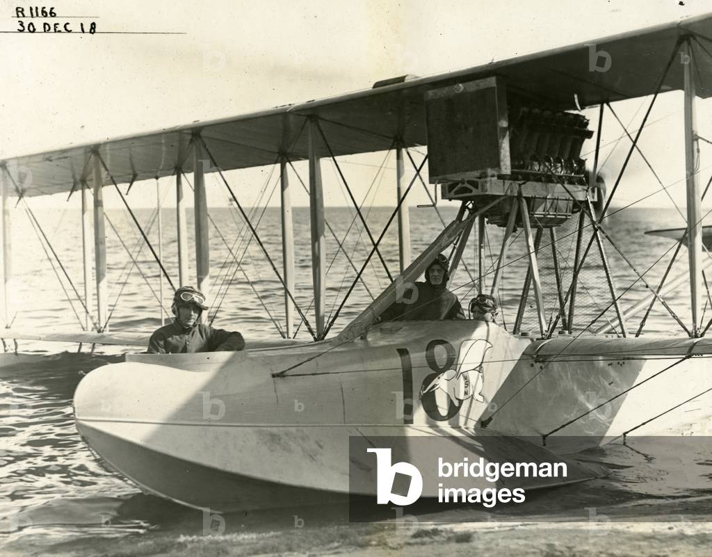 Three navy pilots in a biplane on the shores of Biscayne Bay, 1918 (b/w photo)
