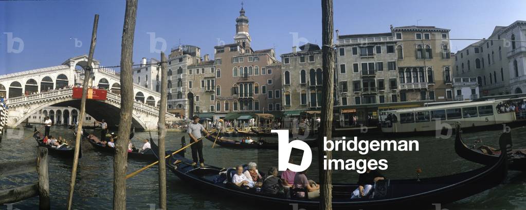 Panoramic view of the Canal Grande, with the Rialto Bridge and the gondolas loaded by tourists, in Venice, Italy