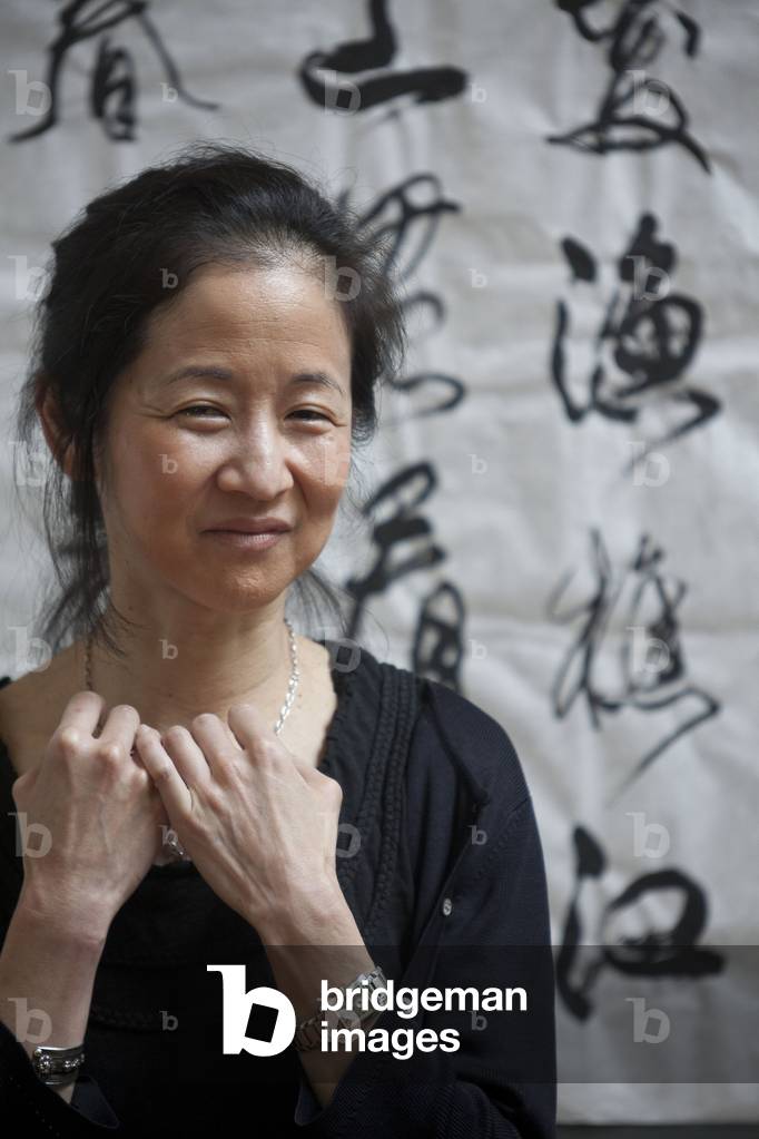 Japanese-American writer Julie Otsuka in front of some works by Chinese master calligrapher Xiao Yunru shown at 