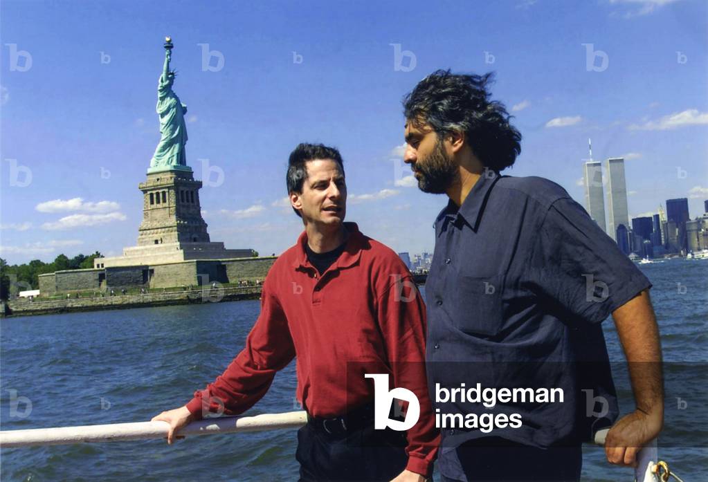 New York City, July 5, 2000. Singer Andrea Bocelli (on the right) and conductor Steven Mercurio on ferry between Battery Park in Manhattan and Liberty State Park. They are in New York City for Bocelli's “Statue of Liberty Concert”” at New Jersey's Liberty State Park in honor of Italian immigrants/New York, 5 July 2000. He singer Andrea Bocelli (a destra) with the orchestra director Steven Mercurio on the traghetto of Battery Park in Manhattan and Liberty State Park. Sono a New York per il concerto di Bocelli sotto la statua della Libert a Liberty State Park in onore degli immigrati italian -