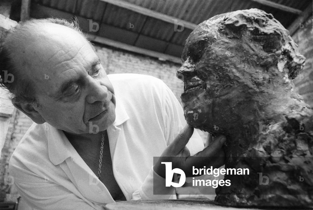 Venice, 1979. Lithuanian artist Arbit Blatas in his studio working at a statue of Mstislav Rostropovich