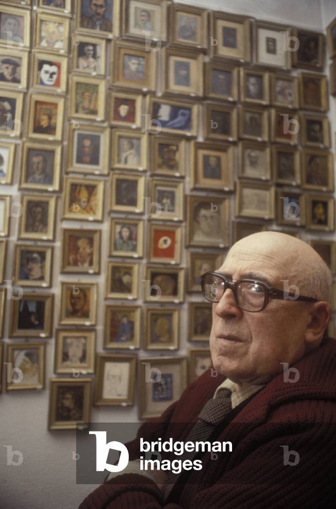 Portrait of writer and painter Cesare Zavattini posing near his collection of miniatures in 1979.