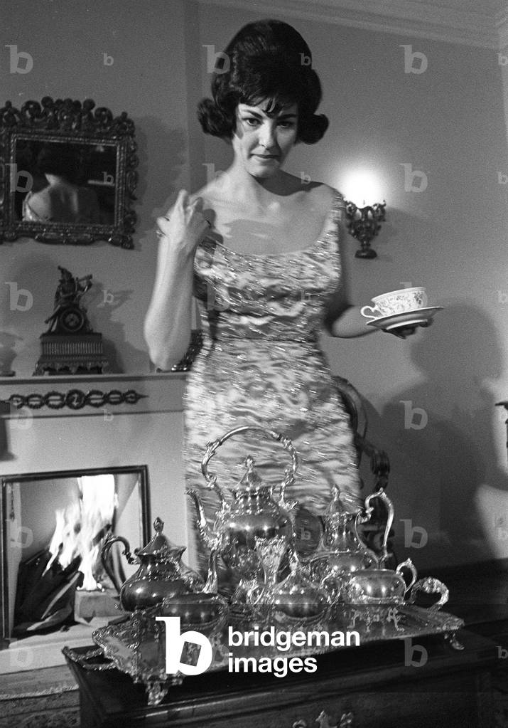 Rome, March 1960 Soprano Anna Moffo in her home behind a tea tray full of silver teapots/Roma, marzo 1960 Il soprano Anna Moffo nella sua casa dietro un vassoio pieno di teiere d'argento - Marcello Mencarini Historical Archives