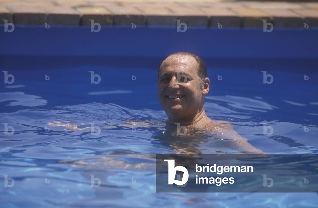 Giardini Naxos (Messina), 1986. Italian TV presenter Renzo Arbore -at Giardini Naxos to receive the National Award for Television Direction- in the swimming pool of the Hilton Hotel (photo)