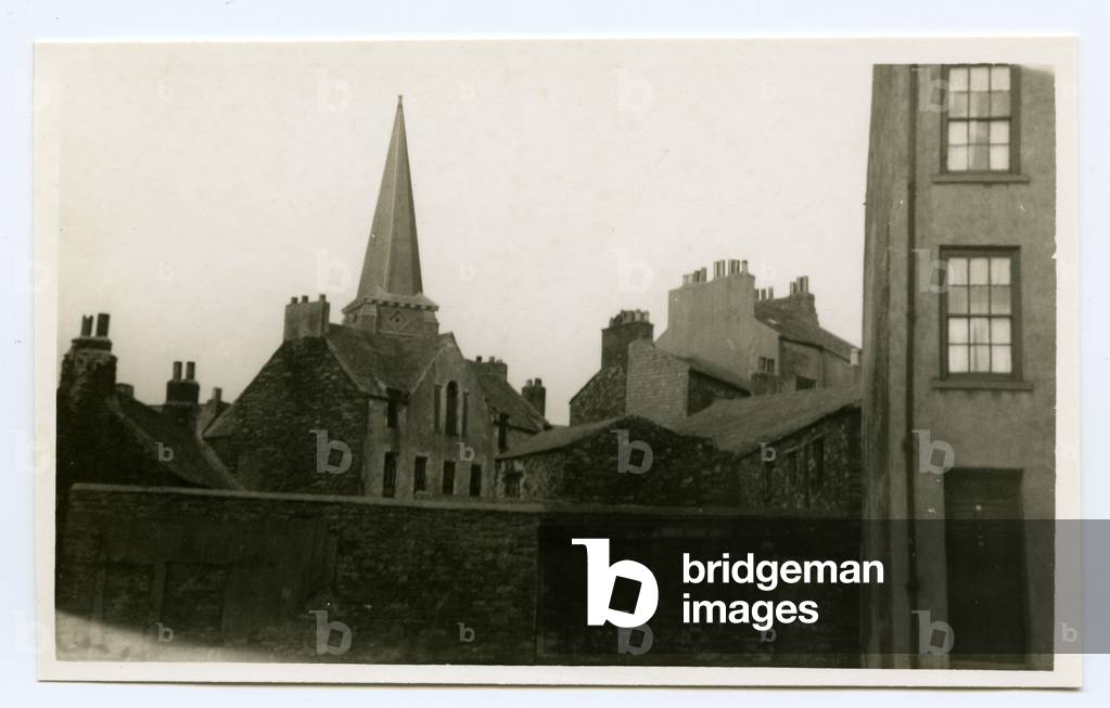 Spire of St Barnabas church behind old building, Douglas, Isle of Man, 1932-34 (b/w photo)