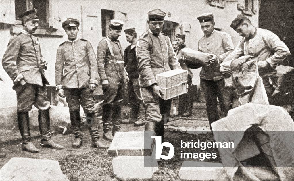 German soldiers, seen here in a French village, recieve packages of food from home during World War One, from The Pageant of the Century, pub.1934