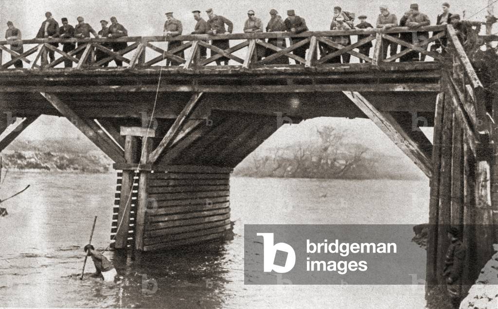 Bulgarian soldiers fishing for guns in the river at Nish, or Ni, Serbia, after the Serb evacuation in 1916, from The Pageant of the Century, pub.1934