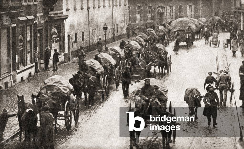 A line of waggons and broken German troops march through Belgium in their retreat at the end of World War One, from The Pageant of the Century, pub.1934