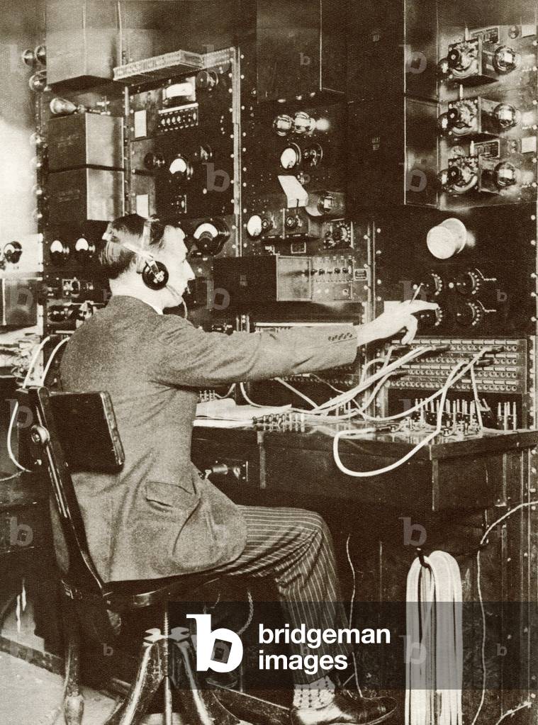 An English switchboard operator speaking to America by radio telephone for the first time in 1926.  From The Story of 25 Eventful Years in Pictures published 1935