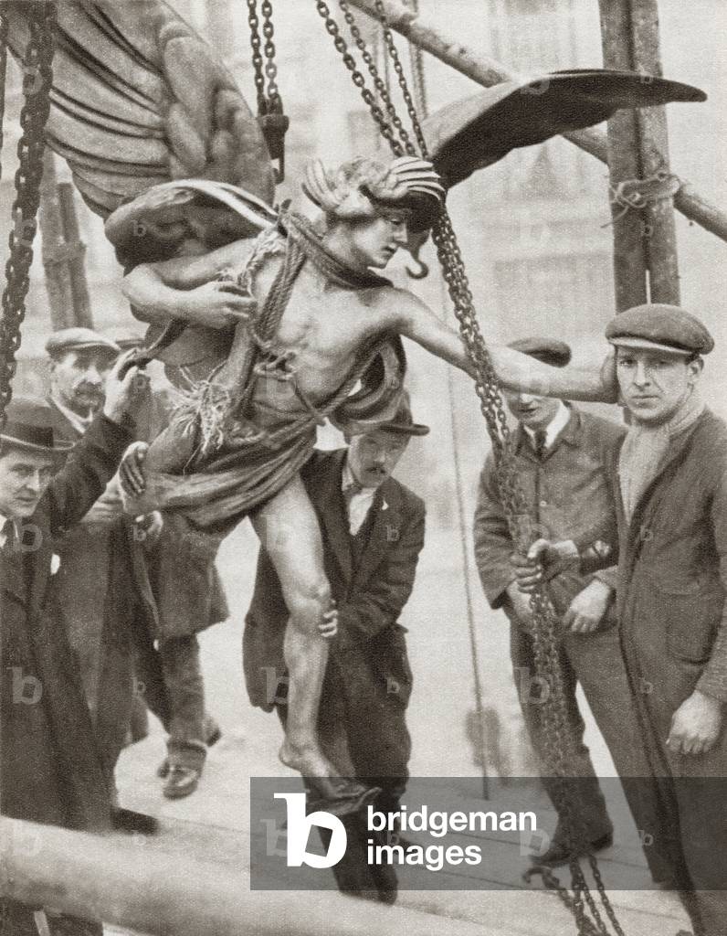 The removal of the statue of Eros from Piccadilly Circus, London, England in 1925 during the reconstruction of the underground railway station.  From The Story of 25 Eventful Years in Pictures, published 1935.