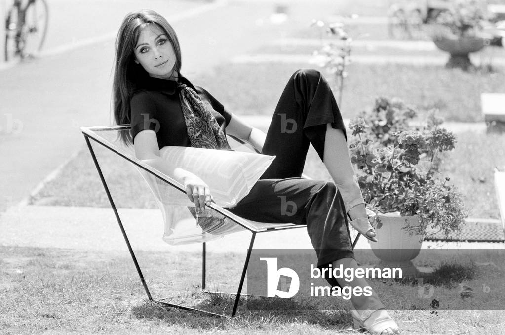 A display of modern furniture, a woman sitting on a transparent chair. 30th June 1969 (b/w photo)