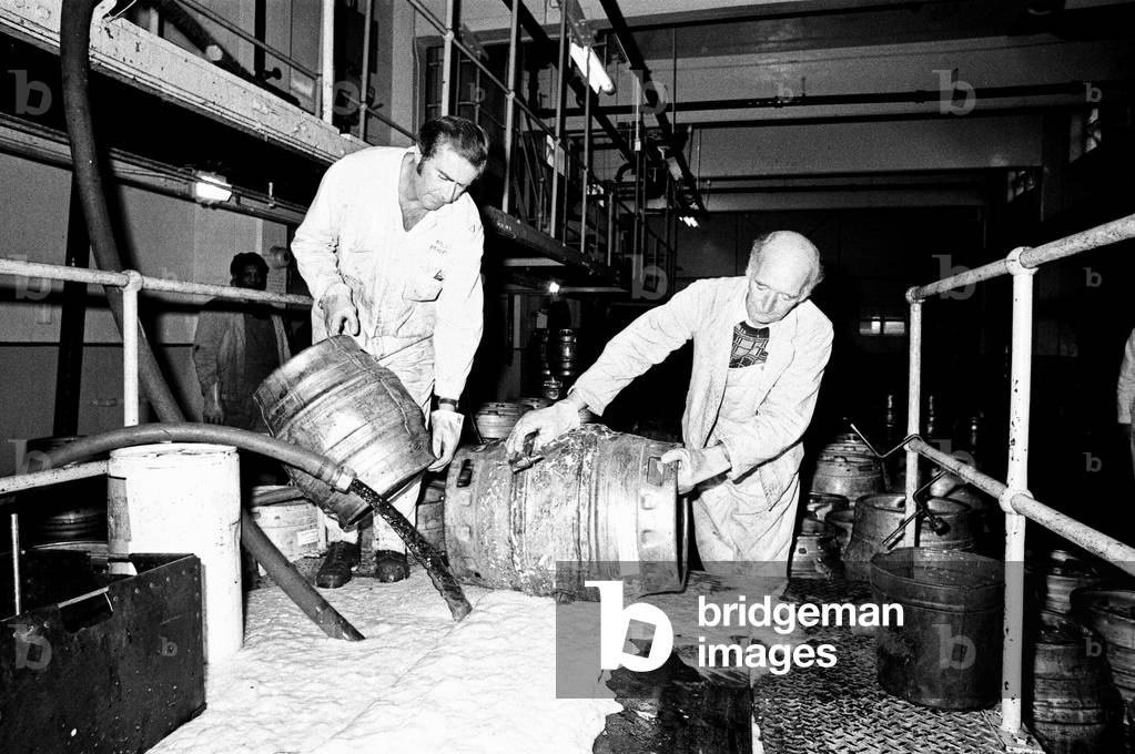 Bob Hudson, Charge Hand in charge of the Beer Disposal Department at Ansells Brewery in Birmingham, pictured with a work mate pouring 600 barrels of beer down the drain due to an industrial dispute. 29th October 1975 (b/w photo)