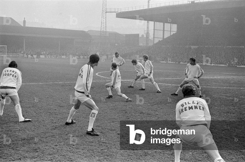 FA Cup Quarter Final match at Elland Road. Leeds United 2 v Tottenham Hotspur 1 The Leeds team led by their manager Les Cocker and captain Billy Bremner warm up on the pitch before kick off, 18th March 1972 (b/w photo)