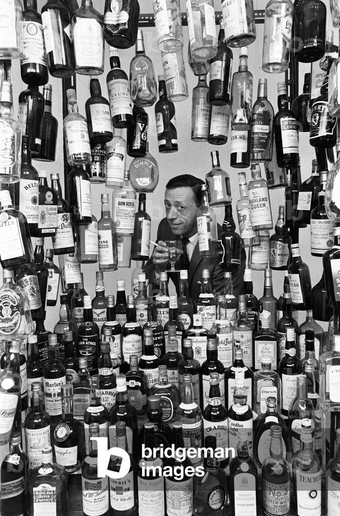 Sunday Mirror writer Stanley Shivas with the 137 best selling Scottish whiskeys. 13th October 1967 (b/w photo)