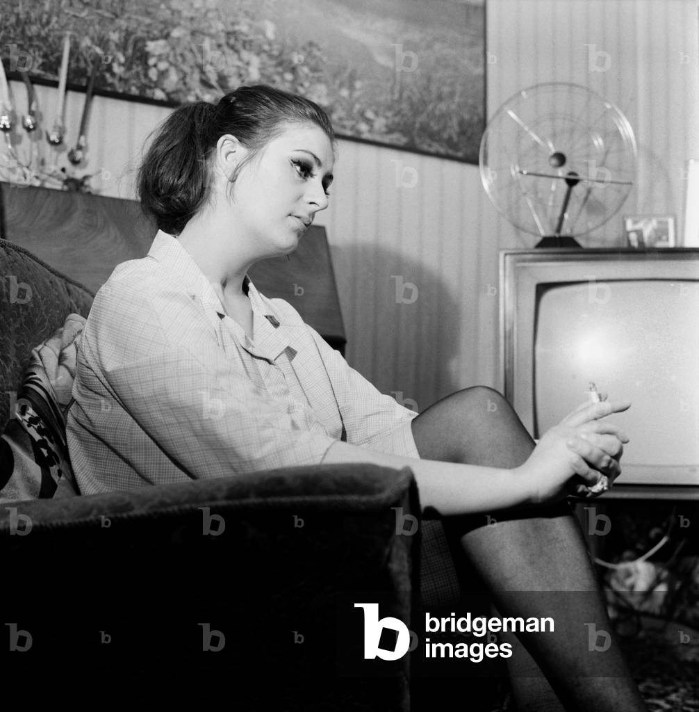 Miss Pat Browne (21) who is an assistant nurse or helper at the Alexandra House, Maitland Park Road, Hampstead, home for old ladies. Pat Browne is a chain smoker - about 200 cigarettes a week, which is her great luxury. November Z11372-002