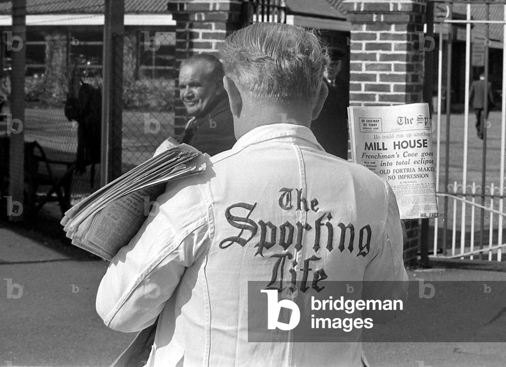 A newspaper vendor selling copies of the Sporting Life before a race
March 1963