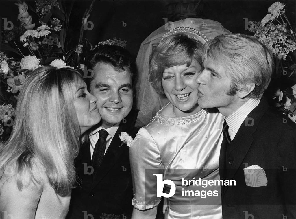 Jackie Irving kisses Tony Hatch while Adam Faith kisses Jackie Trent after the wedding, 19th August 1967 (b/w photo)