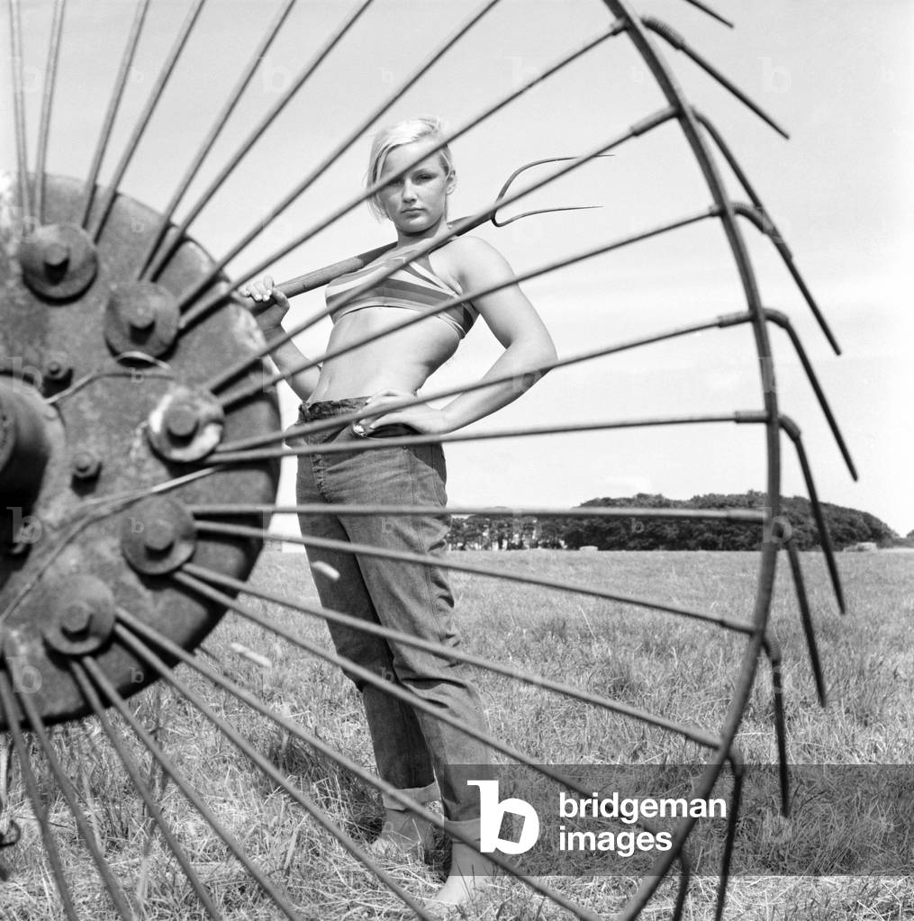 Model Maja Hafernik working on the farm, 1965 (b/w photo)