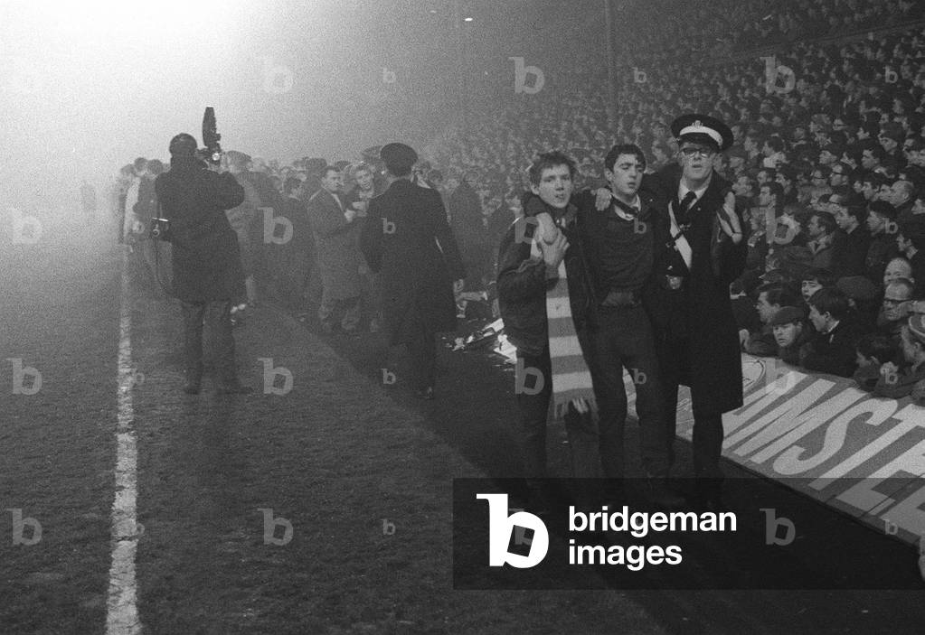 European Cup Second Round Second Leg match at Anfield. Liverpool 2 v Ajax 2 (Amsterdam win 7-3 on aggregate). Police and St John's ambulance worlers tend to dazed and injured spectators who were pushed onto the pitch from the Kop as fans pressed forward for a better view of the action in the low hanging fog. More than 200 were injured in the crush. 14th December 1966 (photo)