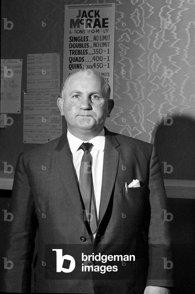 Bookmaker Sidney Glanz inside his betting shop in the Isle of Man. No cash betting is allowed in his shop, June 1969 (b/w photo)