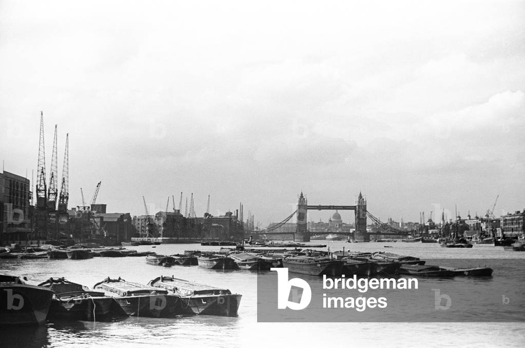 The docks and the River Thames looking towards Tower Bridge and St Paul' s Cathedral. Circa August 1936