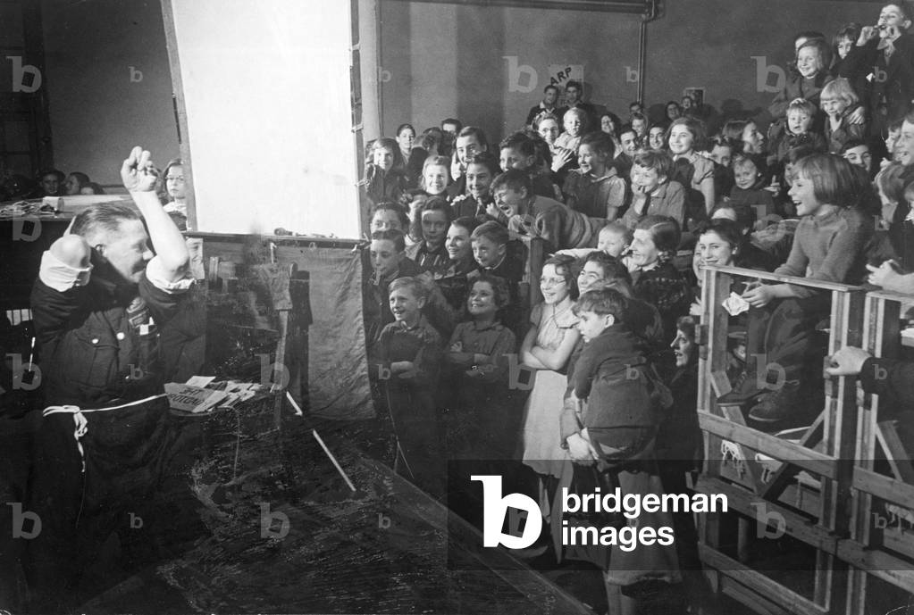 ARP warden John Hunt entertaining school children of Epsom at a South London museum during the Second World war
December 1940
