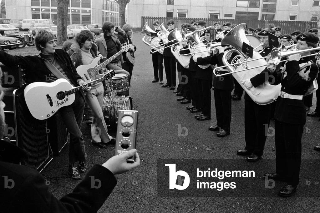 Dave Dee, Dozy, Beaky, Mick and Tich listen while the regimental band of the 1st Battalion of the Parachute Regiment play a number at their barracks in Montgomery Lines, Aldershot. The band is appearing in the show 