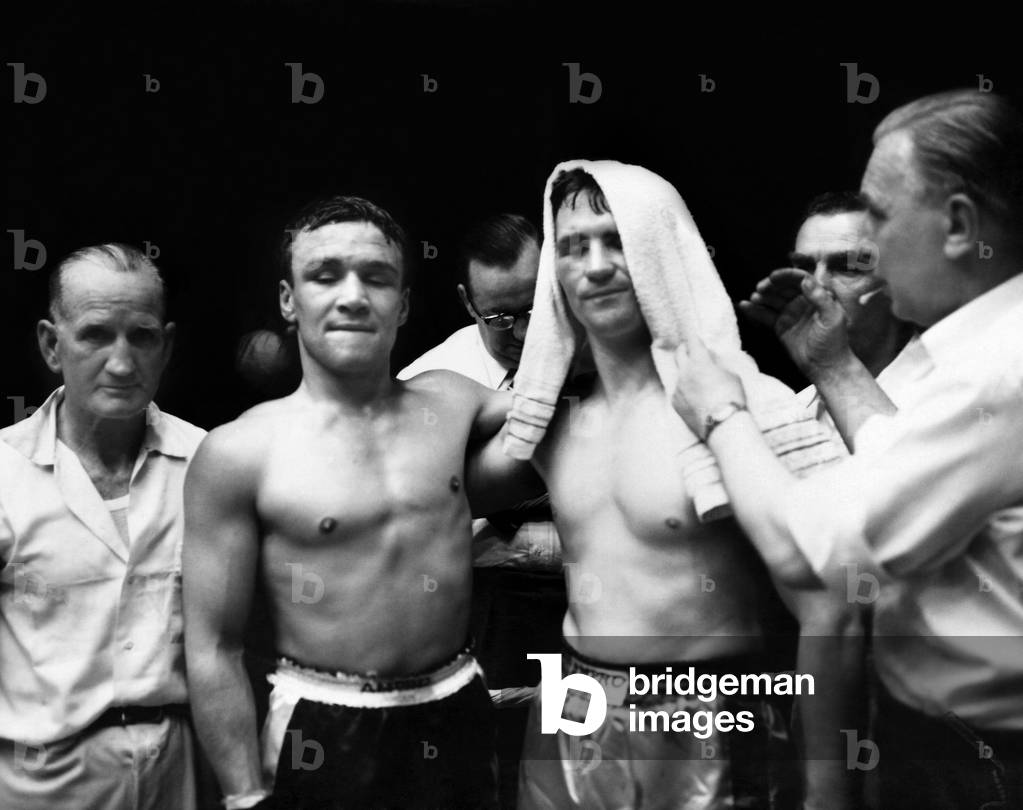 Dave Charnley v Jummy Croll. Jimmy Croll's cut eye is covered as he poses with Dave Charnley, after their fight at Liverpool, was stopped after the fourth round. Charnley won. September 1958