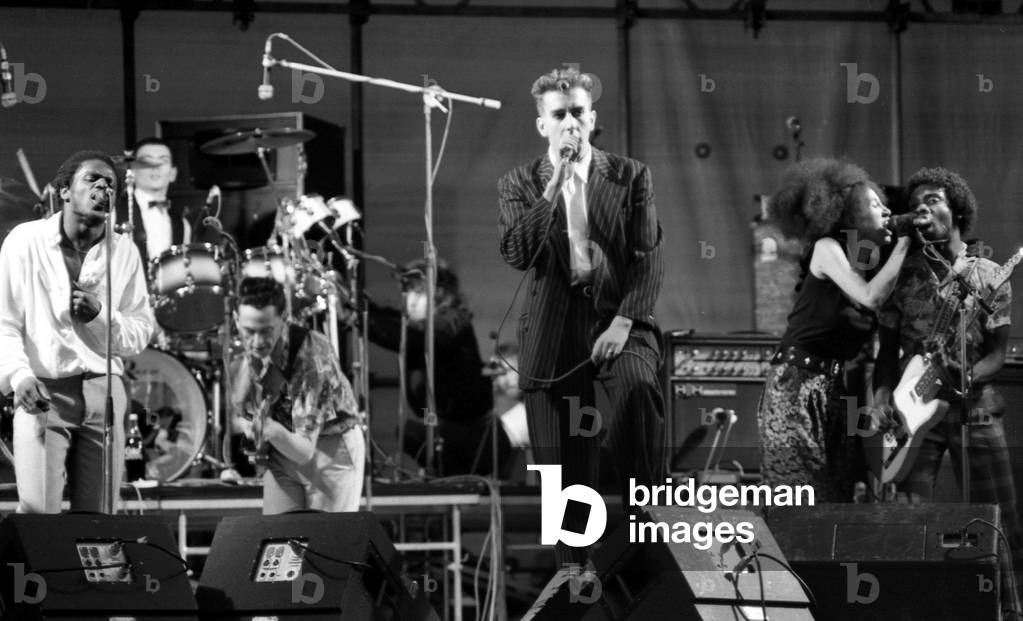 Hazel O'Connor and The Specials performed on stage at the outdoor concert in aid of racial harmony at The Butts stadium in Coventry. Terry Hall singing with The Specials, 22nd June 1981 (b/w photo)
