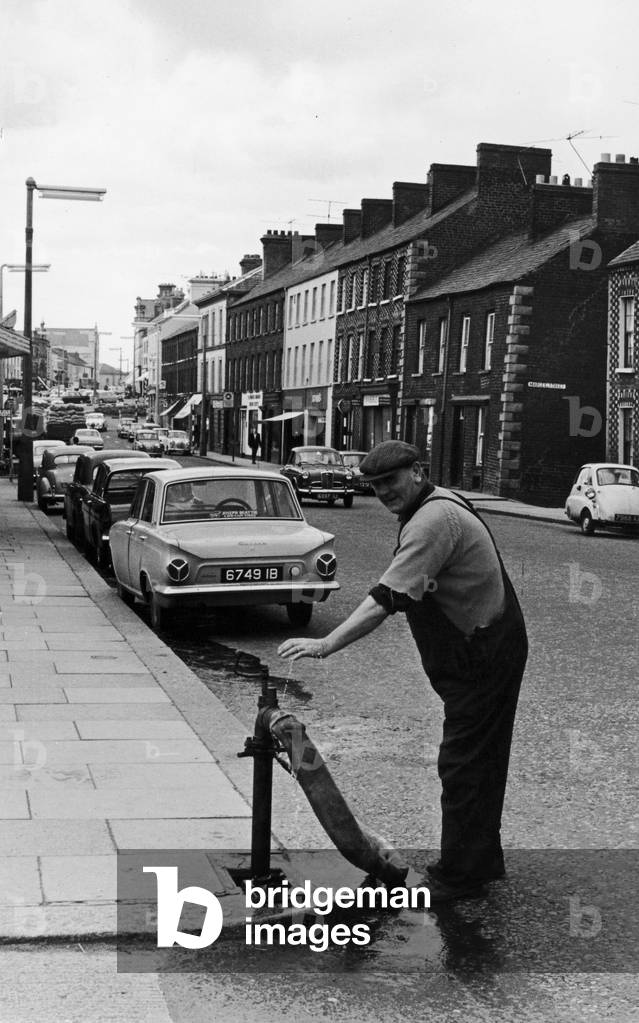 A workman from the local water board seen here working a standpipe in Portadown. Circa 1966