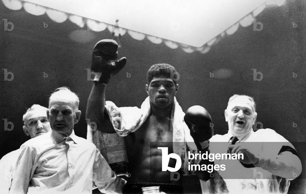London v. Davila: Roberto Davila with his arm raised after beating Brian London in the 5th round when London had to retire with a cut eye. February 1968 (b/w photo)