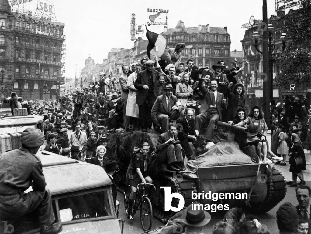 WW2 Belgian citizens welcome British troops to Brussels by jumping on a British tank and riding through the city. 3rd September 1944 (b/w photo)