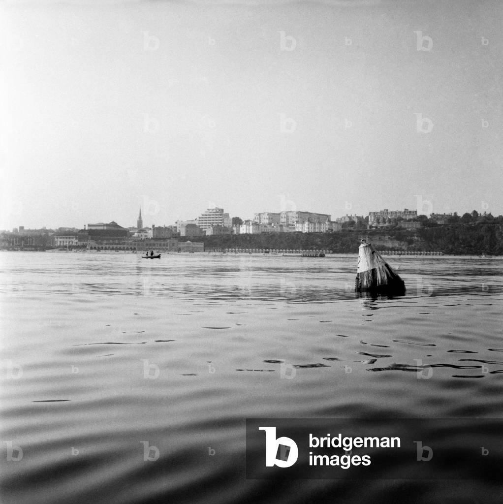 Looking from sea towards Bournemouth with buoy marking sewerage outlet in foreground. June 1960