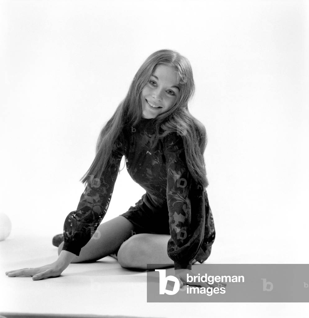Woman poses in the studio wearing a black mini dress. December 1969
