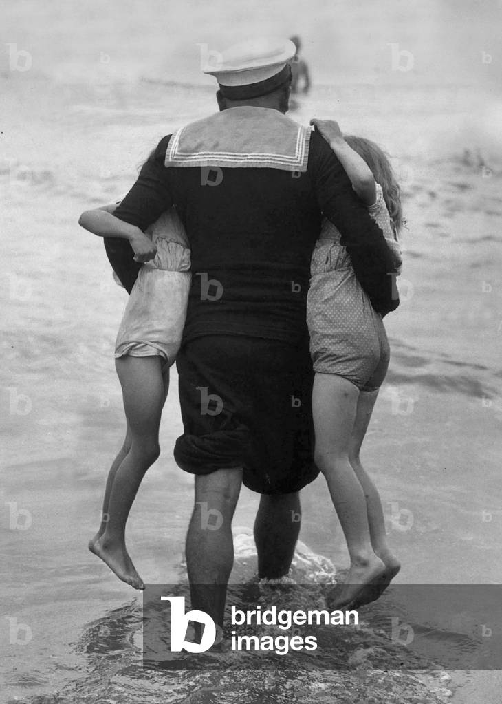 Jack's the boy to try the sea on holiday and is determined to take two little girls under his arms for a paddle, 4 August 1946 (b/w photo)