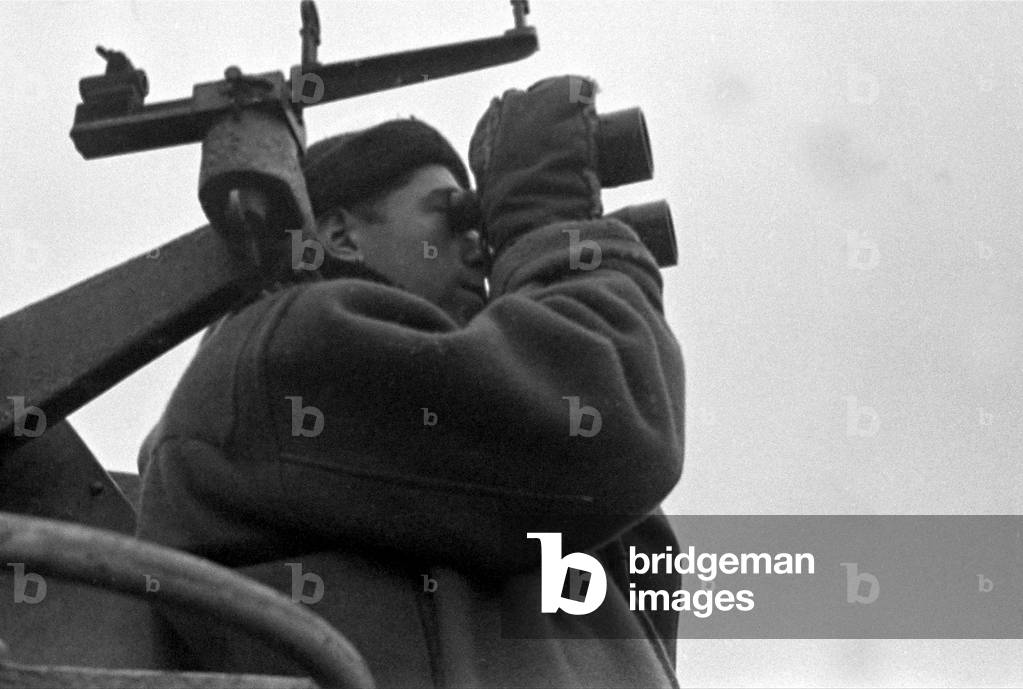 Life aboard a Royal Navy corvette escorting a convoy across the Atlantic at the height of the U-boat offensive against the United Kingdom. A sailor on the look out for enemy aircraft, 1940 (b/w photo)