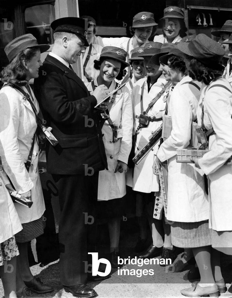 World War II Women: London transport - conductresses seen here reporting to the inspector berfore starting work. This is one of countless jobs now being undertaken by women to free men up for military duty. July 1940