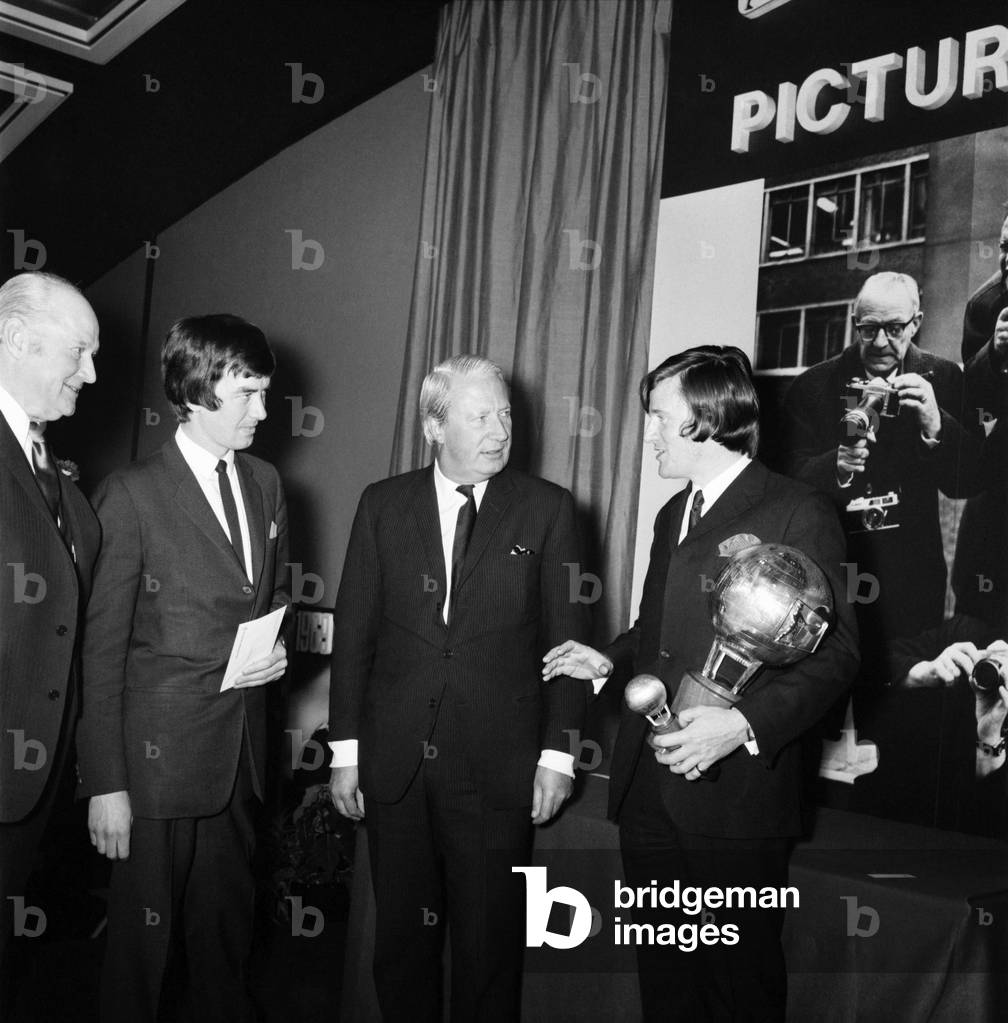 Mr. Edward Heath, leader of the opposition, congratulates Kent Gavin, Daily Mirror, after he was named British Press photographer of the year at the Europa Hotel, London. December 1969