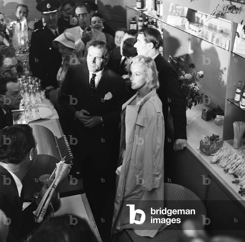 Marilyn Monroe seeking refuge from photographers, London, 1956 (b/w photo)
