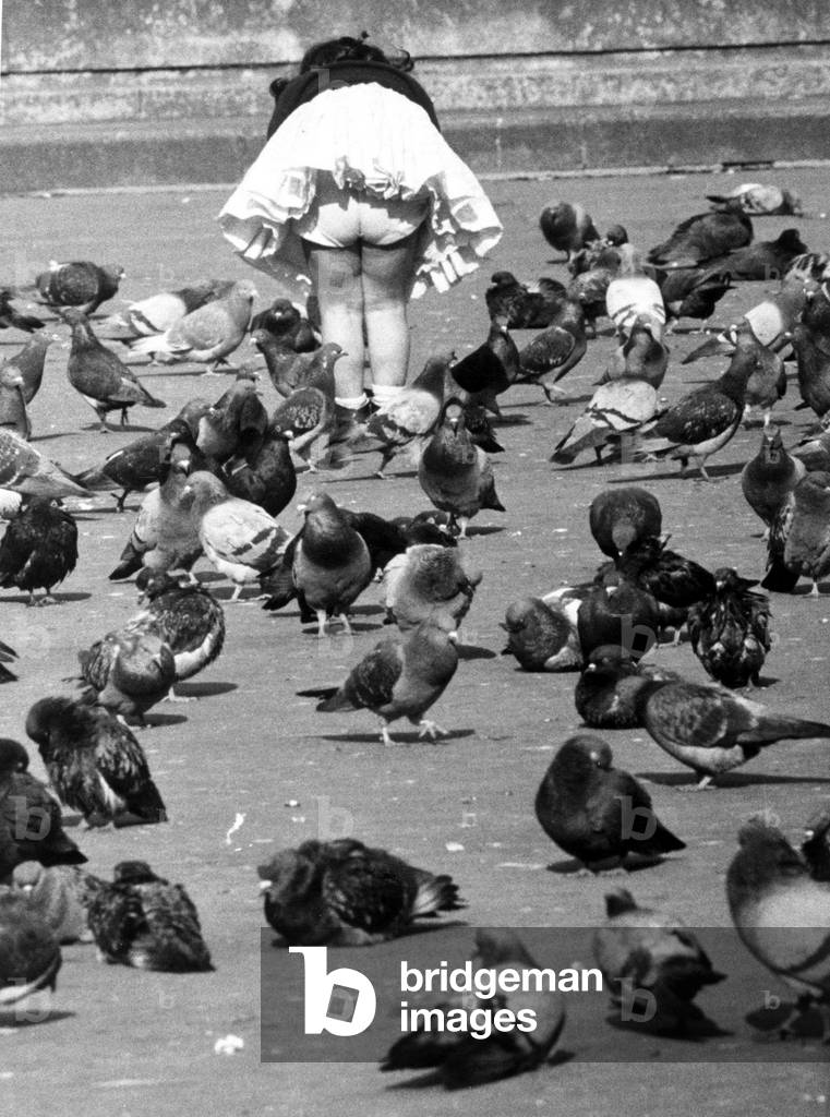 Four year old girl feeding the pigeons in Trafalgar Square
 August 1961