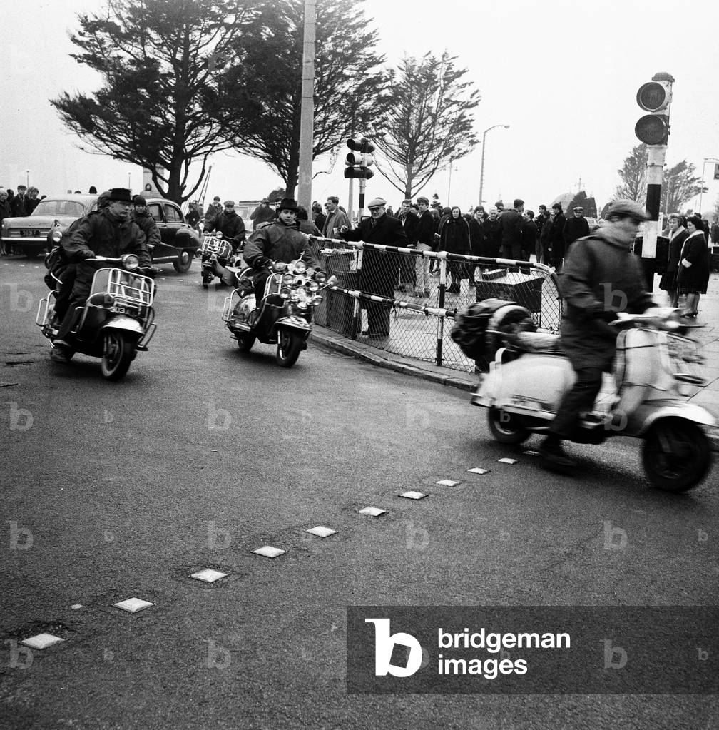 Mods on their scooters seen here driving along Clacton sea front. Over the 1964 Easter weekend several scuffles between Mods and Rockers broke out in the Essex seaside town. 30th March 1964 (b/w photo)