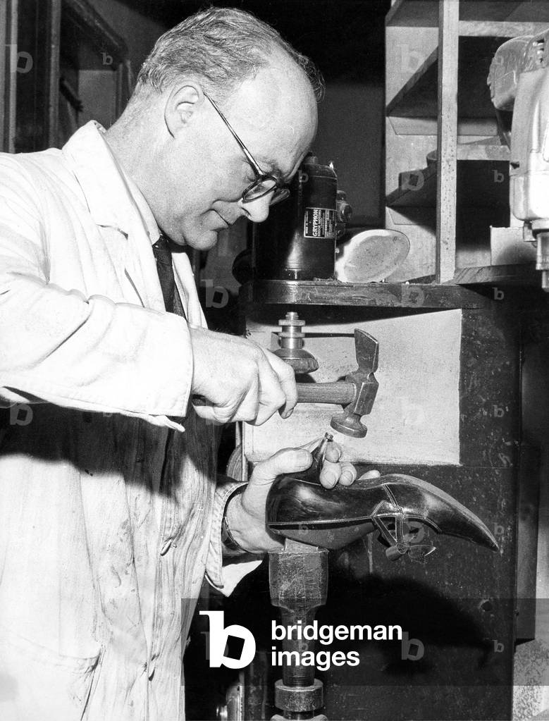 In goes the new tubed heel. Delicately driven home by a master craftsman and the shoe is a s good as new, 1960