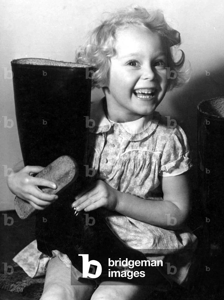 Young girl polishing a pair of wellington boots
Circa 1945